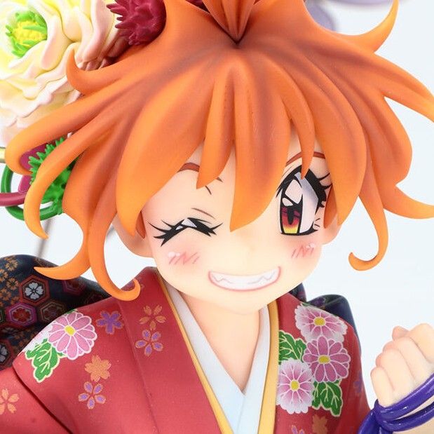 loseup view of an animestyle figurine of a girl. she has bright orange hair styled in a dynamic fashion, adorned with white and red flowers. she's wearing a red kimono with floral patterns, typical of japanese traditional clothing.  her expression is cheerful, with a wink and a wide smile. the figurine's style is chibi, characterized by its exaggerated features and small stature. the overall impression is one of cuteness and kawaii aesthetics. the detail is high, showing texture in the hair, clothing, and flowers.