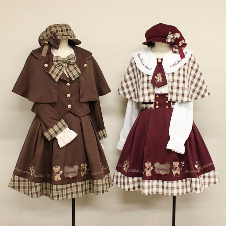 two mannequins are dressed in ouji lolita coordinates. both feature bear embroidery, capes, and matching hats. the left mannequin is primarily brown with brown plaid accents, while the right mannequin is burgundy and white with burgundy plaid accents.