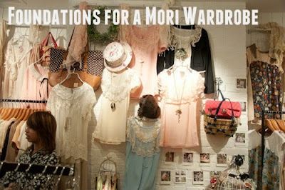 the image shows a clothing store with the text "foundations for a mori wardrobe" at the top. there are many clothes on display, including dresses, blouses, and shirts in light colors like white, pink, and blue. some of the clothes are on hangers, while others are on mannequins. there are also handbags, hats, and jewelry on display. a woman is standing in the foreground, looking to the side. the background is decorated with photographs. the store appears to specialize in a type of fashion called "mori."