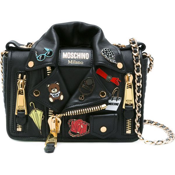 the image shows a moschino black leather shoulder bag designed to resemble a biker jacket. the bag features a gold chain strap, zipper details, and various decorative pins and patches including a teddy bear, sunglasses, a red glove, and the moschino logo. the bag's design mimics a jacket with a collar and asymmetrical closure.
