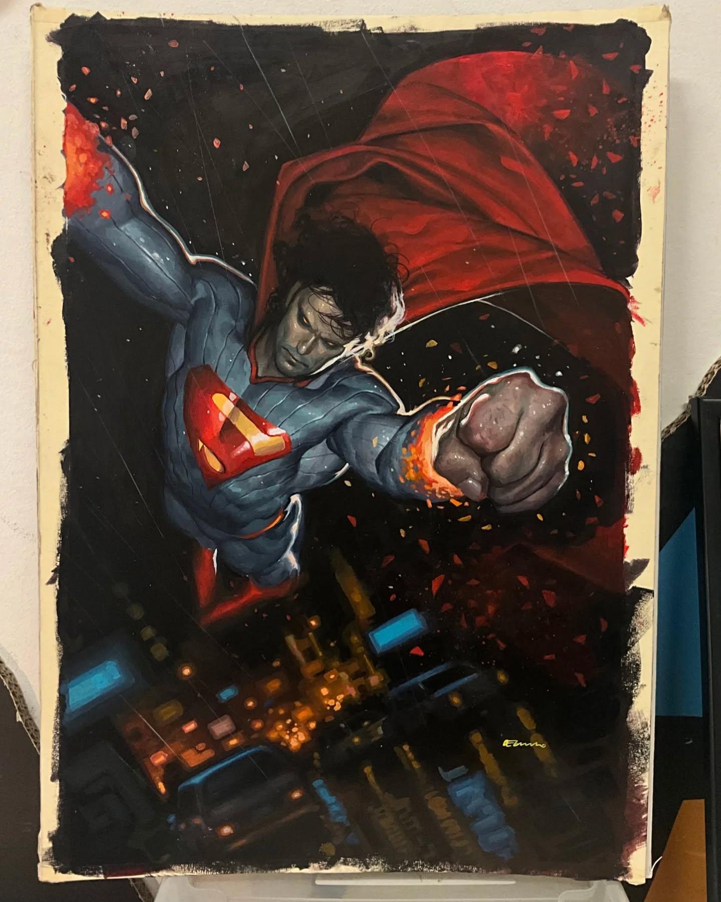 a painting of superman flying over a city at night. he is wearing his iconic blue and red suit and cape. his fist is clenched, and he appears to be flying towards the viewer. the city below is lit up with lights. the painting has a dramatic and powerful feel.