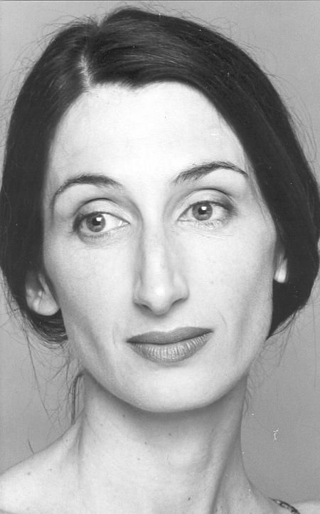 a black and white headshot portrait of a woman with dark hair. she is looking slightly to the left with a neutral expression. the focus is on her face.