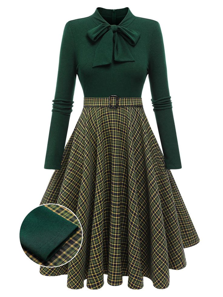 this is an image of a green dress. the top half of the dress is a solid green turtleneck style with long sleeves and a large bow at the neck. the bottom half of the dress is a pleated plaid skirt in shades of green, yellow, and black. there is a matching fabric belt at the waist.  the dress is shown against a white background.