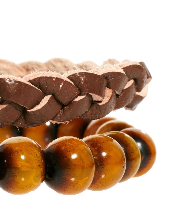 a close up of a brown leather bracelet with brown round beads. the leather is braided and the beads are smooth and glossy.