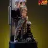 the image showcases a detailed and intricately crafted statue or figurine, possibly resin, depicting a scene from a fantasy or dark fantasy setting.  the figure appears aged and weathered, with a gothic or grim aesthetic.  it is seated or perched on something, possibly a rock or throne, and surrounded by other smaller elements suggesting a dioramastyle presentation. the overall mood is dark and mysterious, hinting at a narrative or story.  the statue is displayed on a dark base. the figure's appearance is somewhat reminiscent of a dwarf, hobbit, wizard, or another type of mythological or fictional character.  the level of detail suggests it might be a highquality collectible.