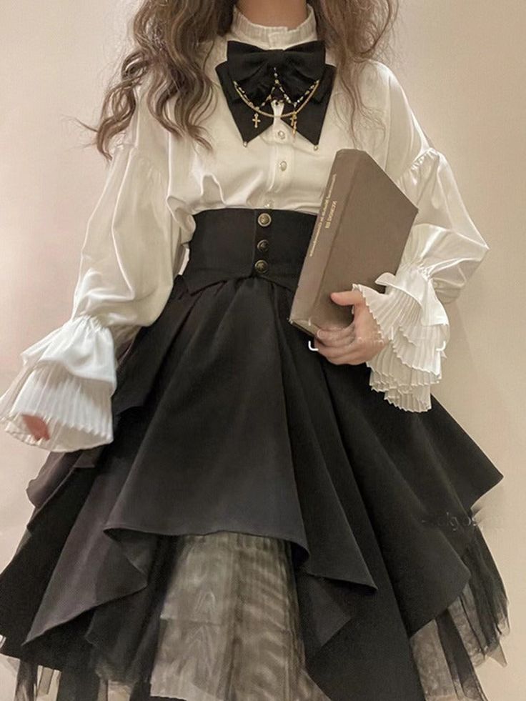 a person is standing while wearing a white blouse with black bow tie and black layered skirt. they are also holding a book.  the image appears to be showcasing an outfit and is taken indoors.