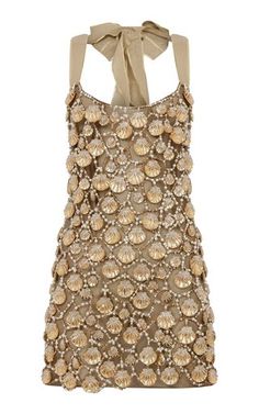 a gold beaded dress featuring seashell embellishments. the dress is sleeveless and has a halter neck style. it is a sophisticated and elegant piece that would be perfect for a summer party or evening event.