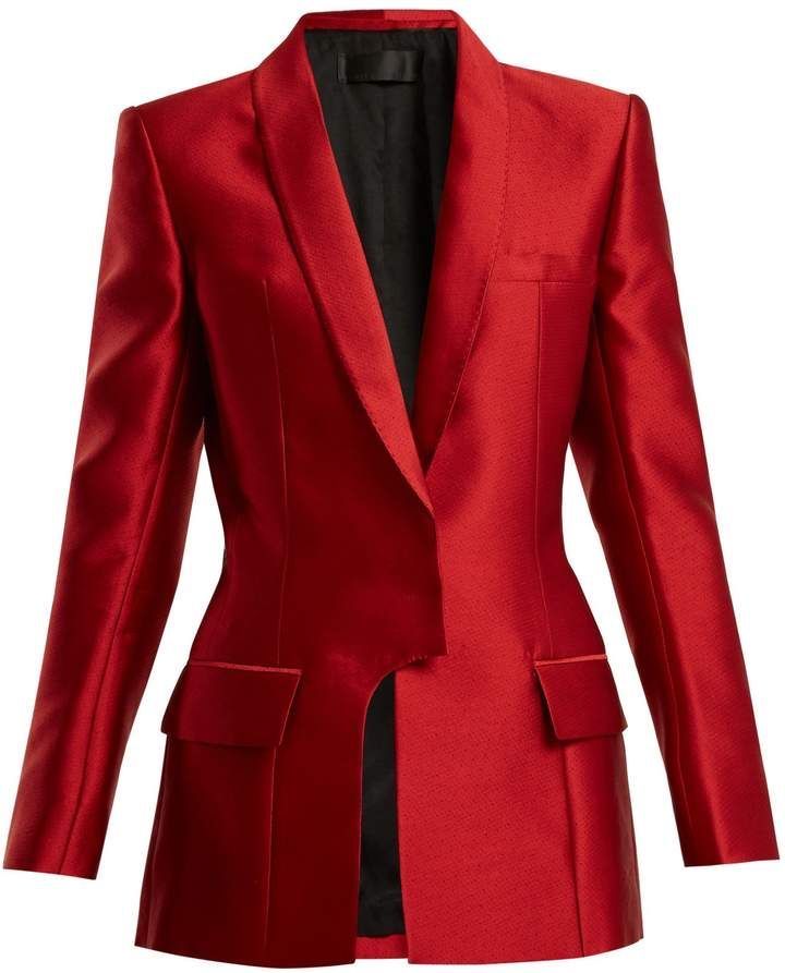 a red satin blazer is showcased in a professional studio shot. the blazer is unbuttoned, revealing a dark lining. it features structured shoulders, a notched lapel, and a singlebreasted design. two flap pockets are visible near the bottom of the blazer.