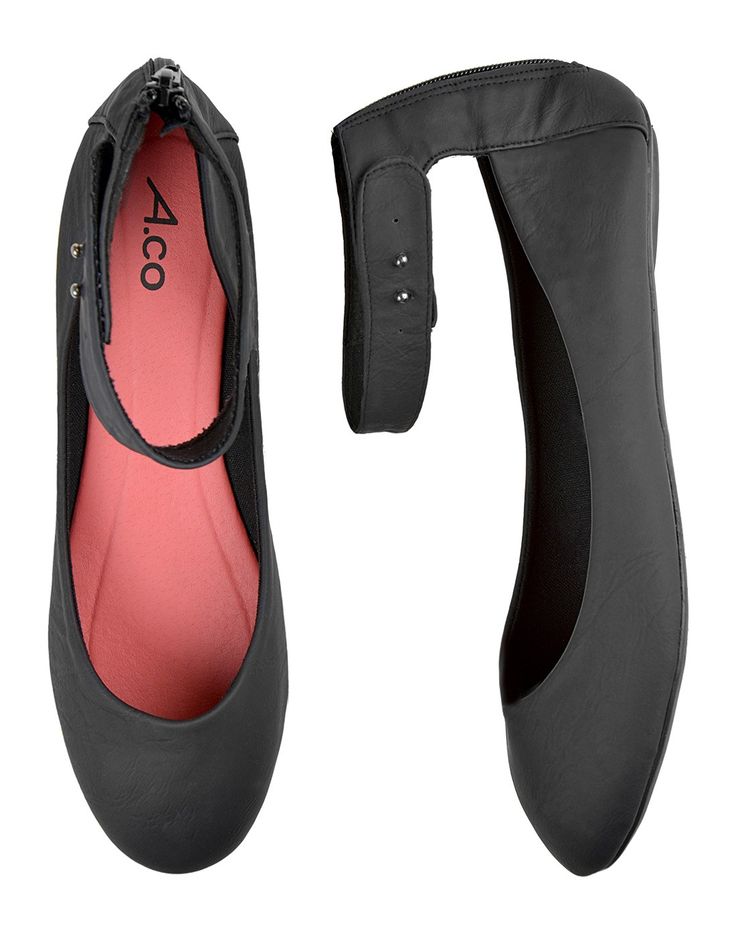 the image shows two black leather ballet flats with ankle straps. one shoe is shown from above, revealing a pink insole, while the other is positioned vertically, showcasing the side profile and adjustable ankle strap. both shoes feature a zipper closure at the back.