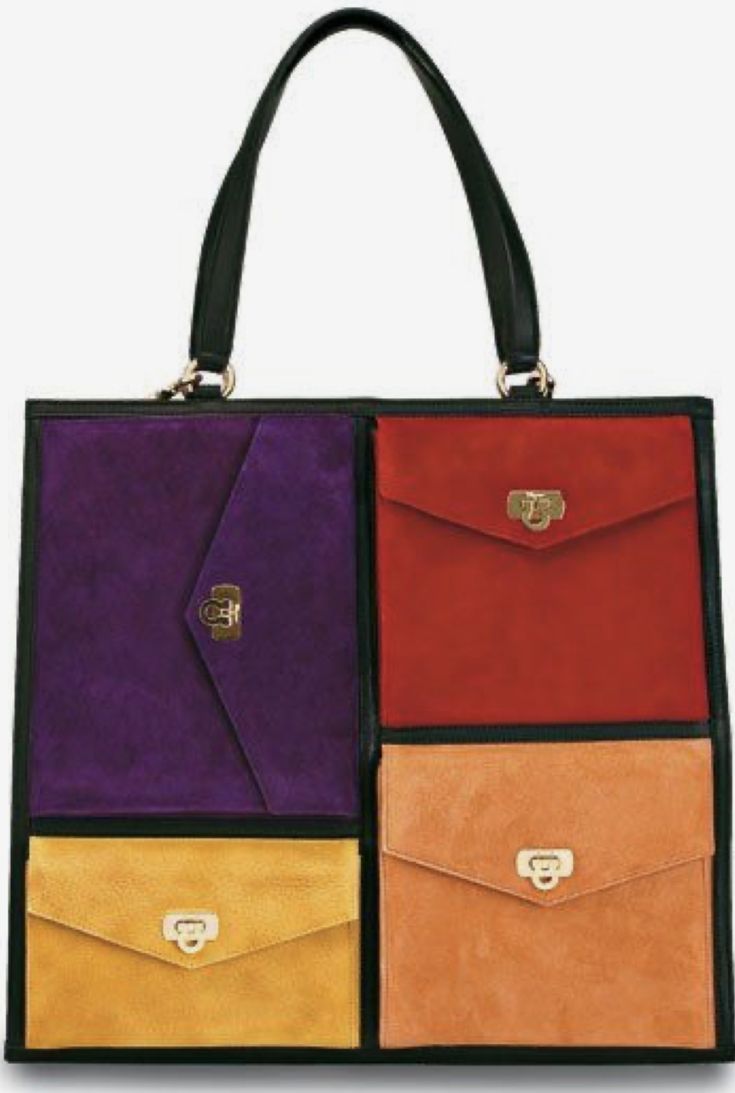 this is a close up image of a woman's tote bag. the bag is made of different colored suede and has a black leather strap. the different colors of the bag are: red, purple, yellow, and orange. the bag is closed and the handle is not shown. the bag is sitting on a white background.