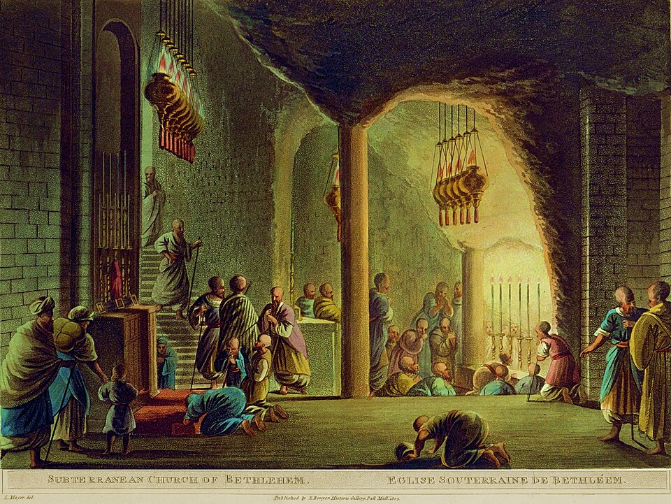 the image shows a historical depiction of the subterranean church of bethlehem, also known as the eglise souterraine de bethléem. several people are present, some kneeling in prayer, while others stand or walk about. there are numerous men and children. the architecture is characterized by stone walls, arches, and cavelike spaces. lit candles and hanging lamps provide illumination. the scene suggests a religious gathering or worship service.
