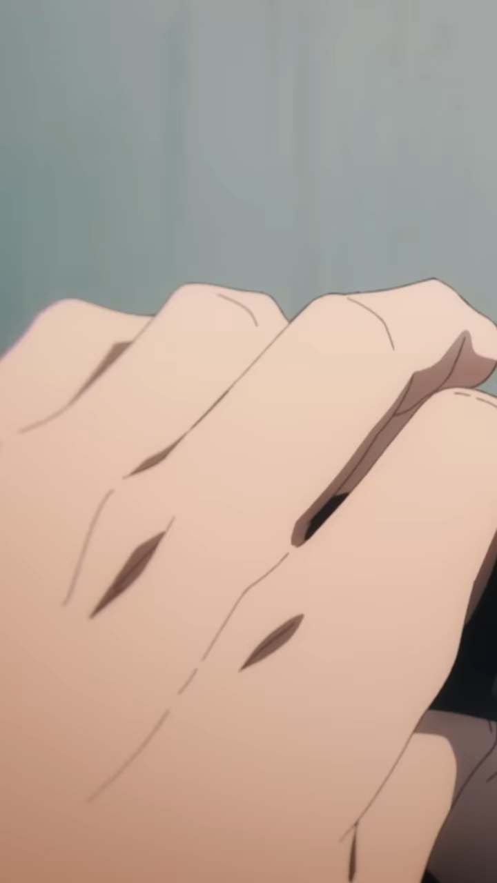 a closeup shot of an anime character's hand, likely a male's hand due to the size.  the lighting appears to be bright and indoors.  the focus is on the middle and ring finger with the index finger out of focus.