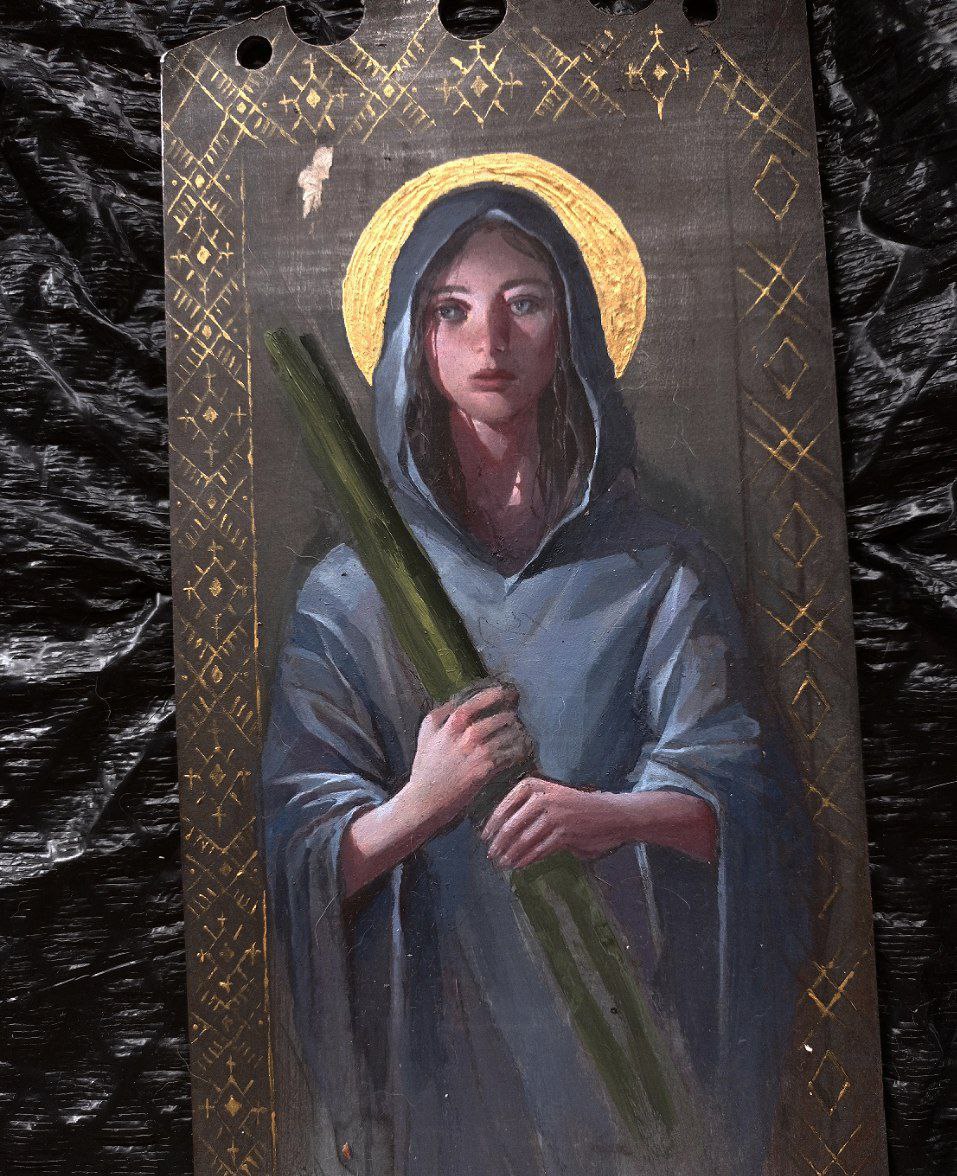 a painting of a woman with a halo and staff. she is wearing a blue robe with a hood and has tears running down her face. the background is dark with a gold border.