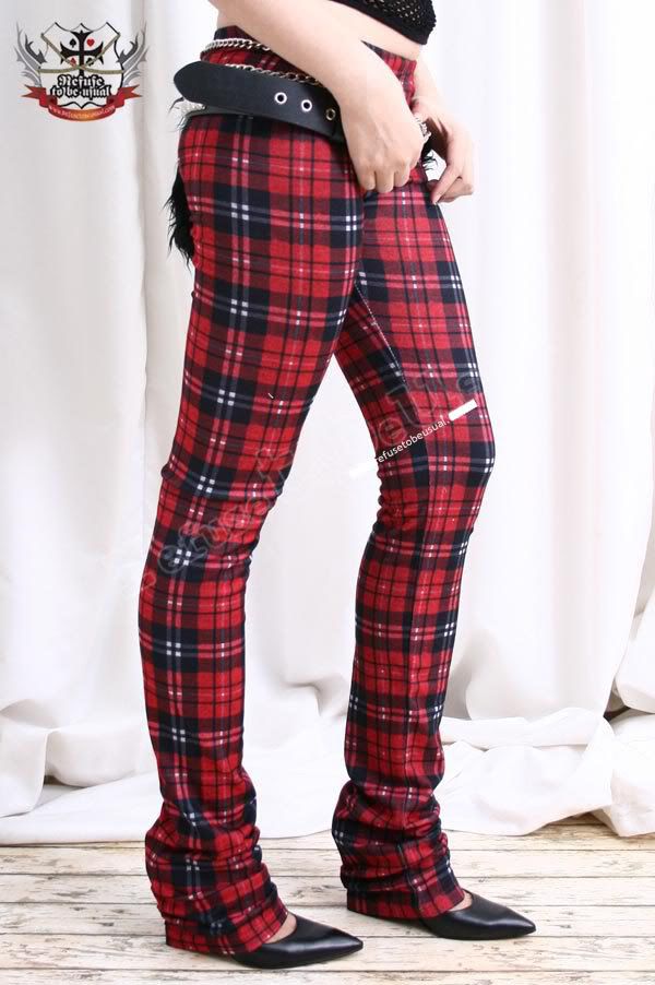 a person is standing wearing red and black plaid pants with black pointed toe shoes. they are wearing a black belt with silver chain. the style is punk fashion.