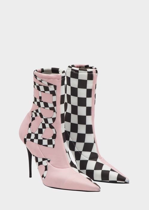 the image shows a pair of women's highheeled ankle boots. the boots are a striking combination of pastel pink and a black and white checkered pattern.  the pink portion features a stylized logo or graphic design incorporated into the checkers. the boots are pointedtoe and appear to be made from a fabric or textile material.  they are presented at an angle on a white background, showcasing both the inside and outside of the boot. the style is modern and bold.