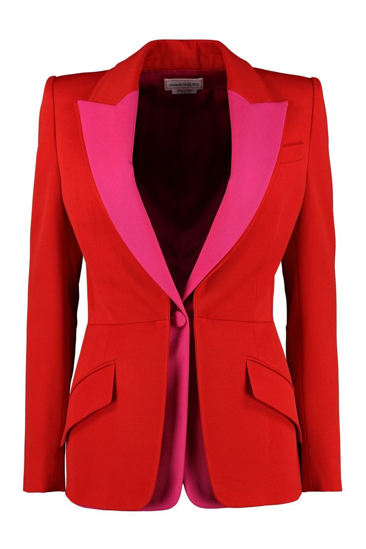 a frontview studio shot of a red alexander mcqueen blazer with pink lapels. the blazer is buttoned at the waist with a single button. the pink lapels extend down to the button and give a pop of color to the blazer. the blazer has two pockets at the front.
