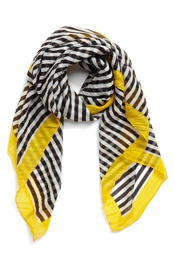 a yellow and black striped scarf, folded and ready to wear.  it is a fashion accessory perfect for adding a touch of color and style to an outfit.