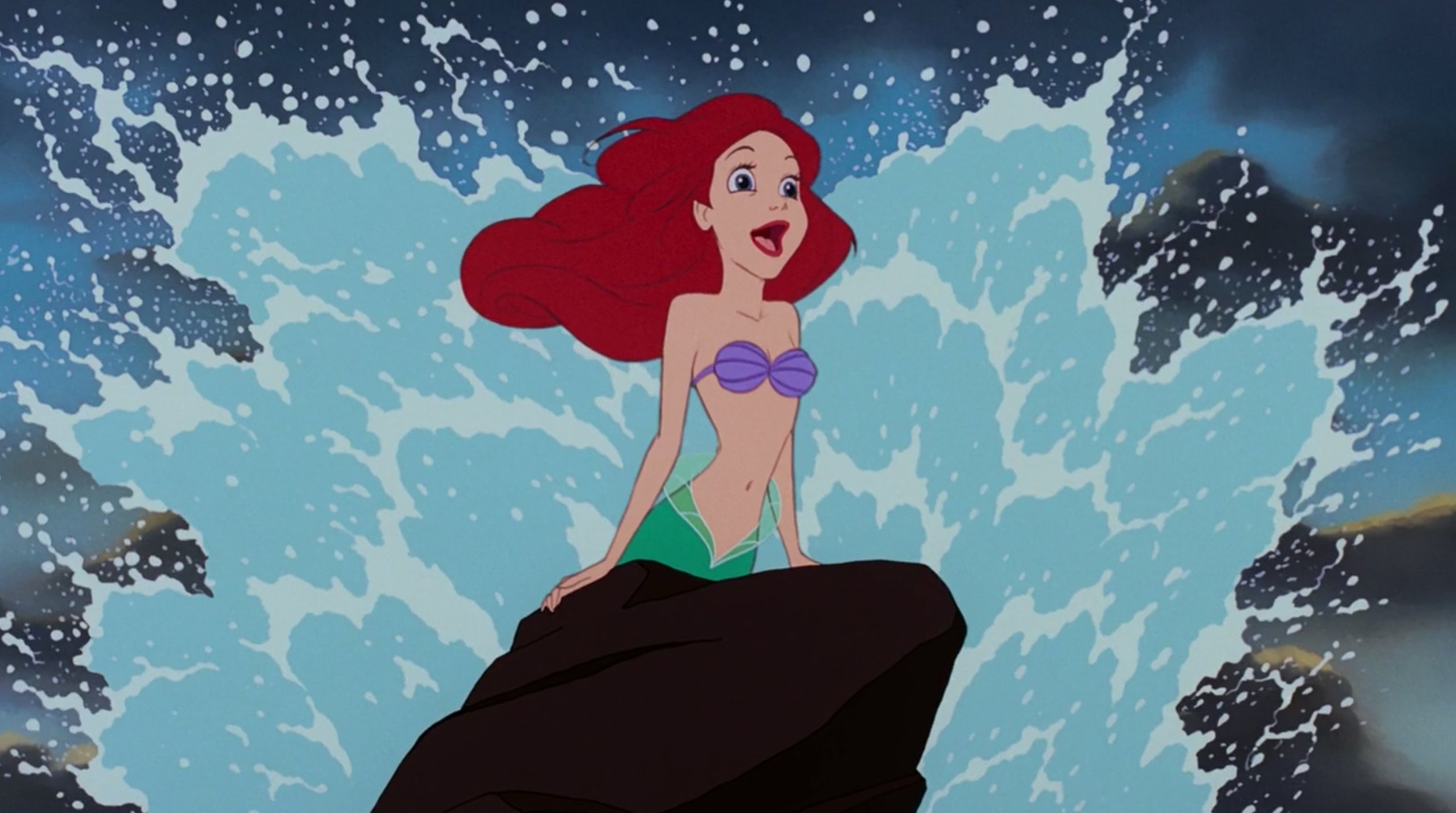 ariel, the redhaired mermaid from disney's the little mermaid, sits atop a rock amidst ocean waves. she is smiling and looking off to the right of the frame. the scene is bright and colorful, with a palette dominated by blues and greens of the ocean.