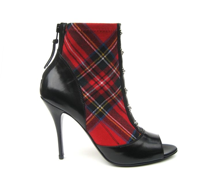 a closeup shot on a white background depicts a highheeled opentoe bootie made of black leather and red tartan fabric. the shoe has a black leather toe cap, heel, and upper section, while the instep and ankle area are covered in a red tartan pattern. the bootie features a high stiletto heel and a small zipper at the back of the heel.