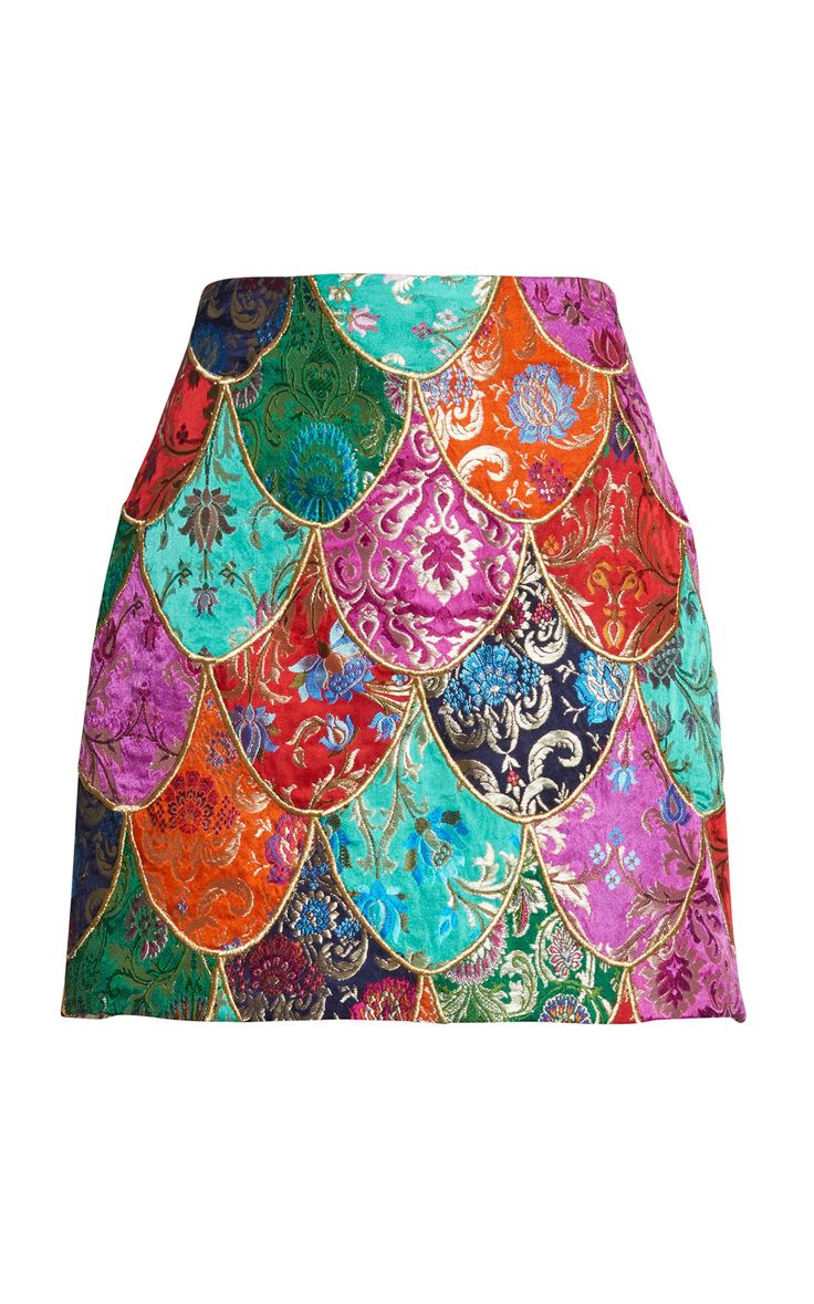 a mini skirt featuring a colorful patterned design, resembling scales or scallops. the fabric appears to be a brocade or jacquard type with a floral damask pattern.