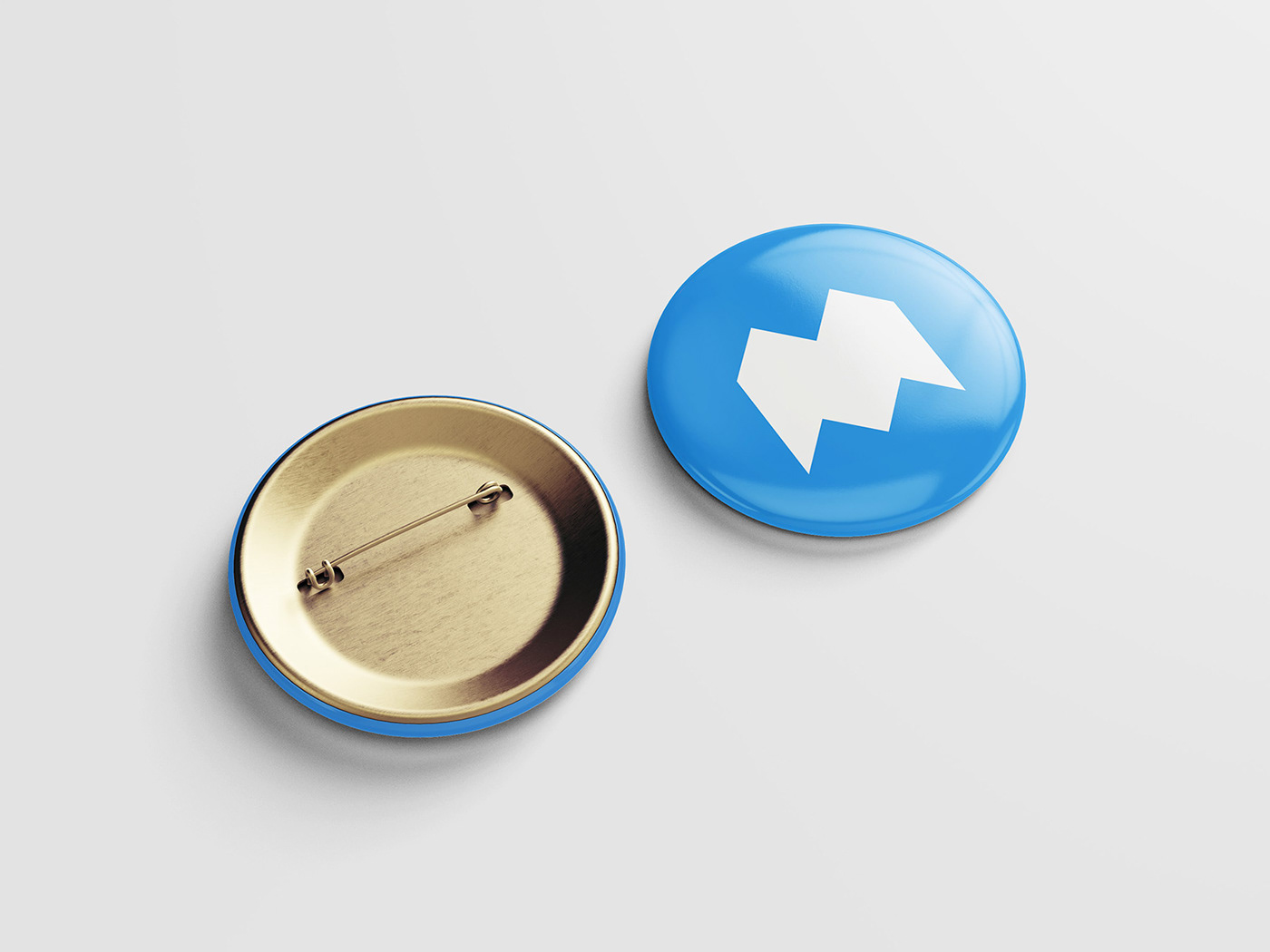 this image shows the front and back of a circular button badge mockup. the front of the badge is blue with a stylized white "n" in the center. the back of the badge is gold and shows the pin mechanism.  the background is a clean white.