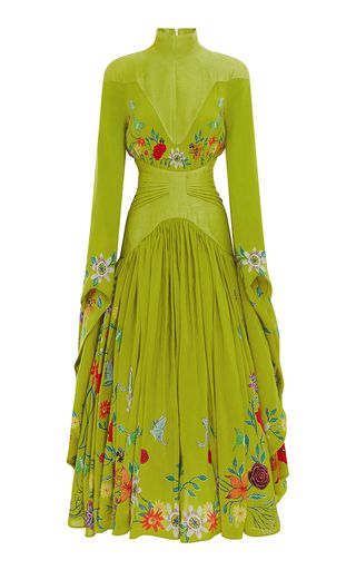 a green maxi dress with long sleeves and a high neck is displayed against a white background. the dress has a fitted bodice with floral embroidery around the neckline and shoulders, and a flowing skirt with floral prints along the hem.