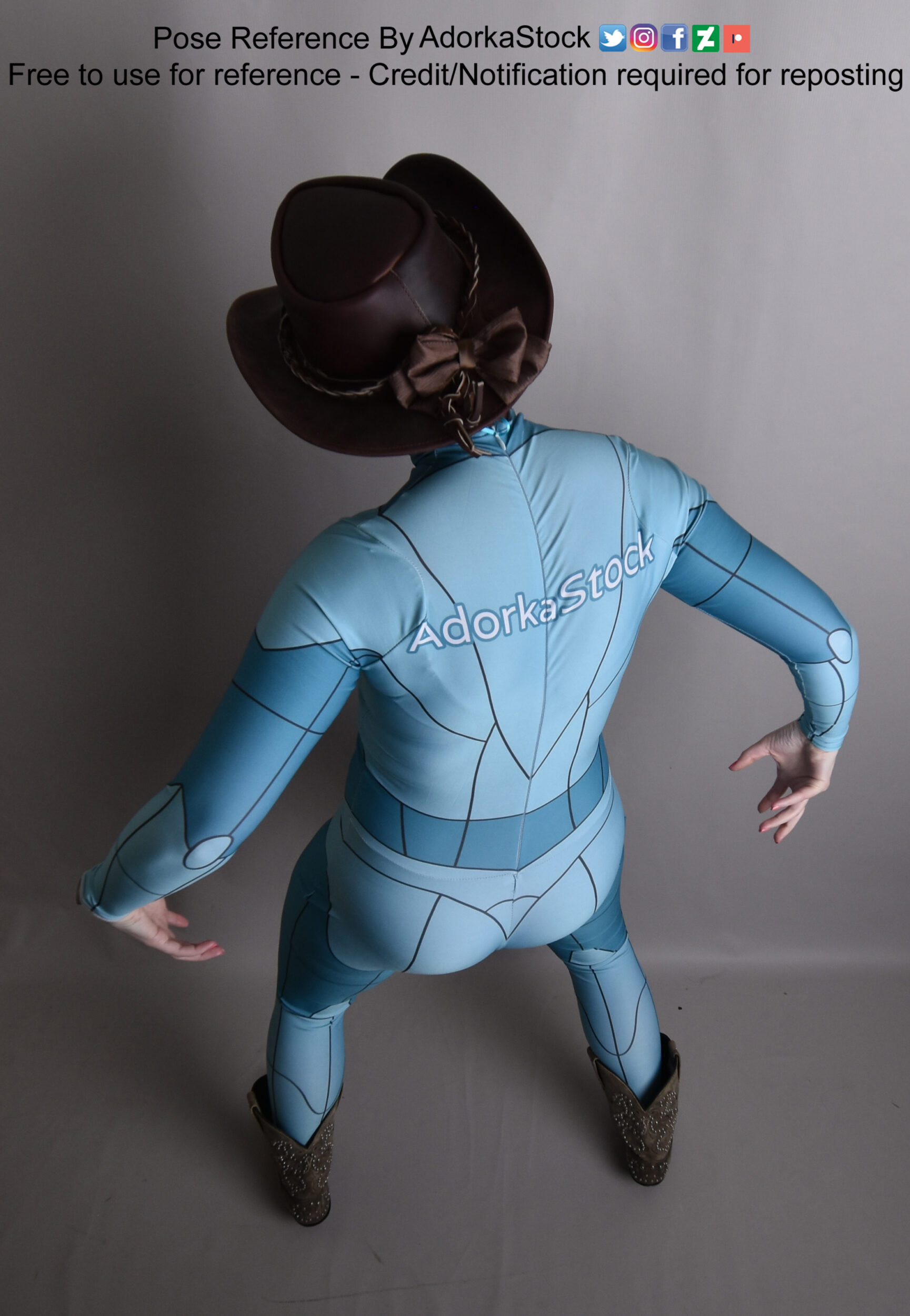 a rear view photo of a woman wearing a blue bodysuit and brown cowboy hat. she is in an action pose with her left leg forward and right leg back, and her left arm extended out. the photo is a pose reference for artists.