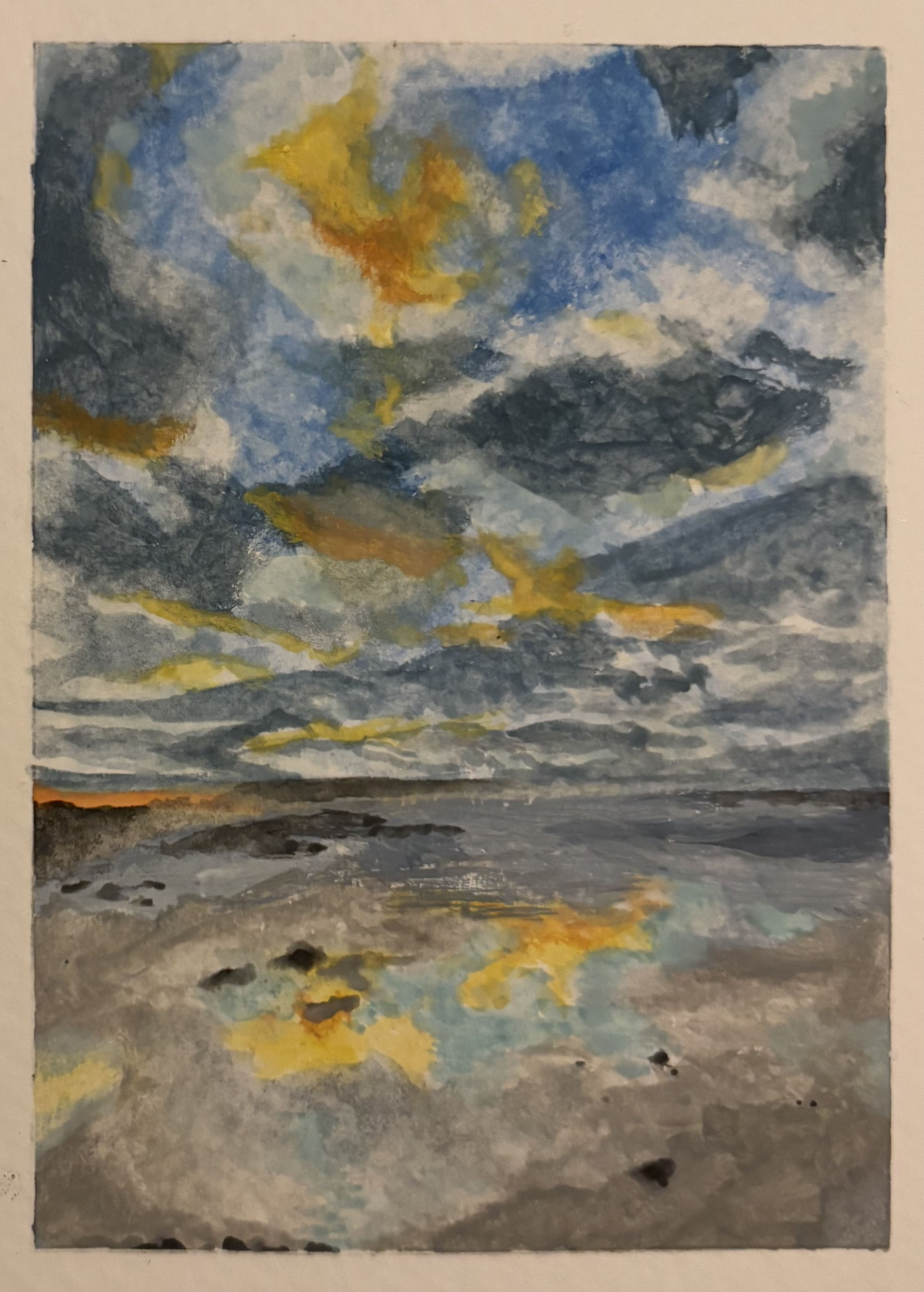 a watercolor painting depicting a seascape with a cloudy sky reflected in the water. the sky is predominantly blue and grey with patches of yellow suggesting the sun breaking through the clouds. the water and shore are grey with yellow reflections mirroring the sky. there are rocks along the shore and the horizon is visible in the distance.