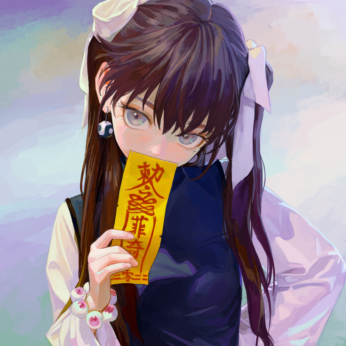 an animestyle girl with long brown hair tied with white bows in pigtails is holding a yellow paper talisman with chinese characters in front of her mouth. she has grey eyes, dark blue dress, and is wearing an earring on her left ear. a bracelet with eyeballs is visible on her left wrist. she is looking directly at the viewer.