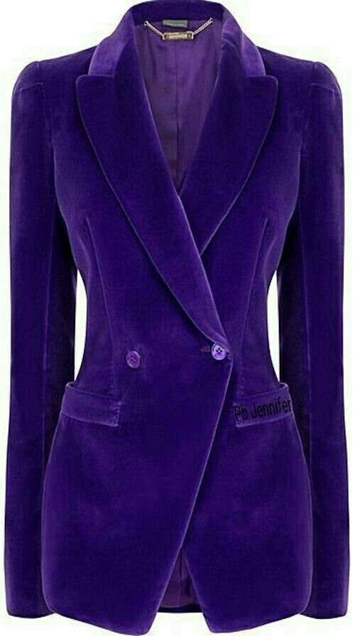 a vibrant purple velvet blazer is displayed against a neutral background. the blazer features a doublebreasted design with button closures, exuding a formal and tailored aesthetic. the luxurious velvet texture and rich color enhance its elegant and sophisticated style, making it a striking piece of women's fashion.