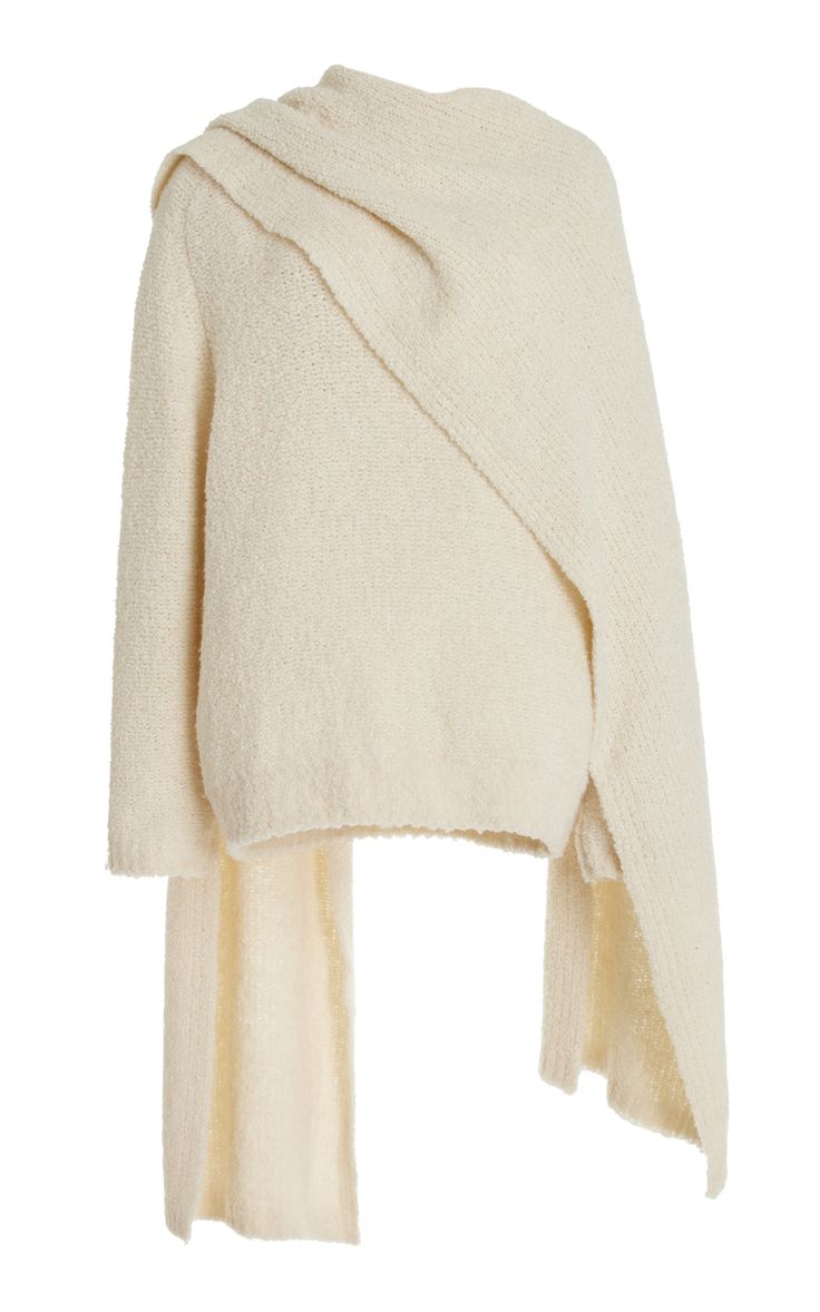 a white, longsleeved, oversized knitted sweater with a cowl neck. the sweater is designed to be worn wrapped around the body, with one side longer than the other. it's a casual, comfortable and cozy garment perfect for fall and winter.