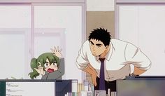 a man and a girl are standing in an office. the man is leaning over a desk and the girl is sitting at her desk. they both look surprised.