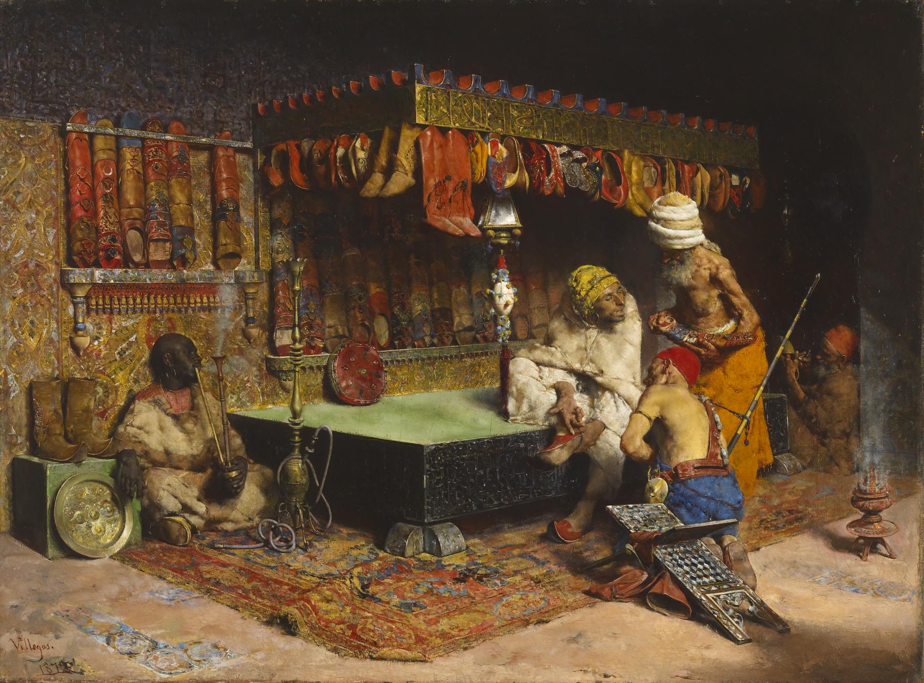 the painting depicts an opulent interior scene, likely from the ottoman empire era. several men are present, adorned in turbans and traditional clothing. one man is seated on a raised platform or divan, while another is kneeling before him, appearing to attend to his shoes or belongings. a darkskinned man is seated in the foreground, smoking a hookah, and another man in the background is playing a pipe. the room is richly decorated with carpets, cushions, and a display of shoes hanging on the walls. the overall scene conveys a sense of luxury and oriental opulence.