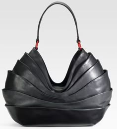 a black leather handbag with a pleated design. the bag has a single strap and a structured shape. the bag is elegant and sophisticated.