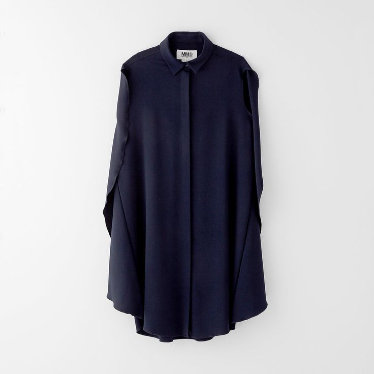a navy blue longsleeved buttonup dress with a collar is hanging against a white wall. the dress is a simple style with wide, flowing sleeves.