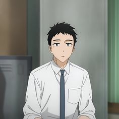 a young man with short black hair and brown eyes is pictured from the chest up.  he is wearing a white buttondown shirt with a dark blue tie, suggesting he is wearing a school uniform.  he has a melancholic expression with slightly downturned eyebrows. the setting appears to be a school hallway or classroom, judging by the lockers visible in the background.
