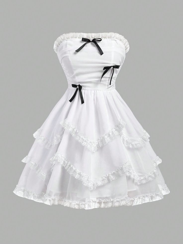 a white strapless dress with black bows. the dress has a sweetheart neckline and a layered skirt with lace trim. the dress is short and would be suitable for a party or other special occasion.
