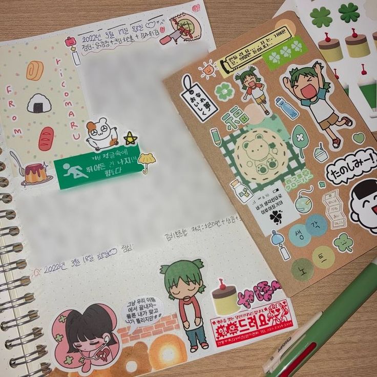 a closeup of an open journal with a  variety of stickers. the journal has a simple, white design with light gray grid lines. the stickers are colorful and feature characters, food, drinks, and objects. the stickers are mostly from korean brands and feature korean text. there is a pen lying on top of the journal.