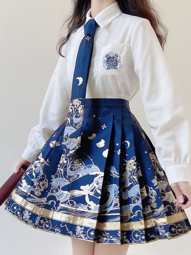 a woman is wearing a white buttondown shirt, a blue and gold patterned tie, and a matching blue and gold pleated skirt. the skirt features a celestial design with waves, stars, and mythical creatures. she is holding the bottom hem of the skirt slightly, showcasing its full pattern.