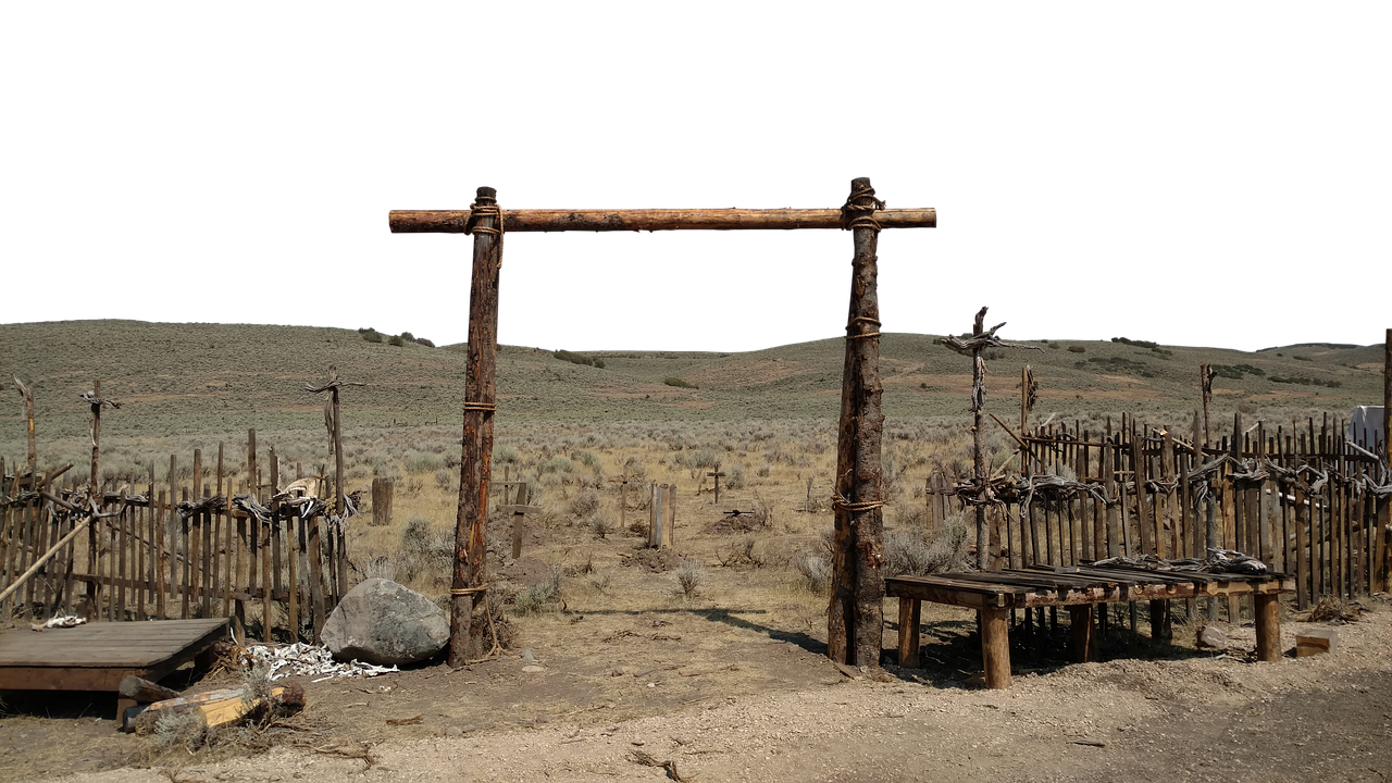 the image depicts a desolate western graveyard situated in a desert landscape. a wooden gate stands at the entrance, flanked by a weathered fence adorned with animal bones and crosses. a bench and a platform are also present within the graveyard, adding to the eerie atmosphere. the backdrop features a barren desert terrain under a dark sky.