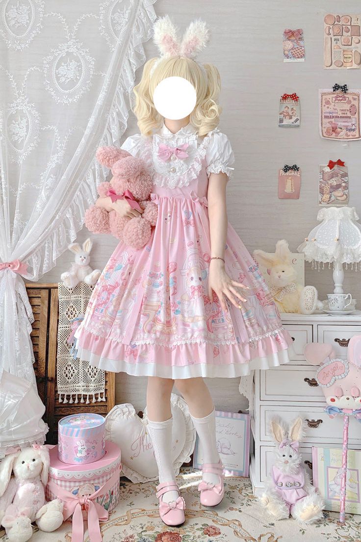 a woman is posing in a brightly lit bedroom. she is wearing a pink lolita fashion dress with a teddy bear print. she is also wearing white bunny ears. the room is decorated in a kawaii style with lots of pink and white. there are teddy bears and other cute items around the room.