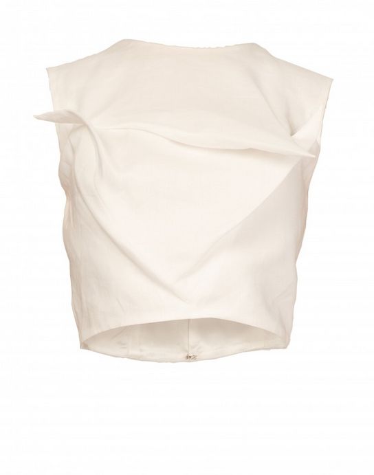 this is a closeup image of a women's white sleeveless crop top. it has a minimalist design with a slightly ruffled neckline. the top is made of a light, smooth fabric that drapes beautifully. it would be perfect for a casual summer outfit.