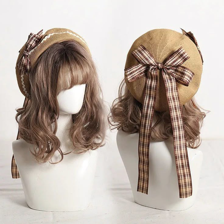 the image features two mannequins wearing brown berets with plaid bows. the mannequins have wigs with light brown hair. the background is a plain white surface. the first mannequin is positioned on the left, and the second is on the right. the bows are on the back of the beret.