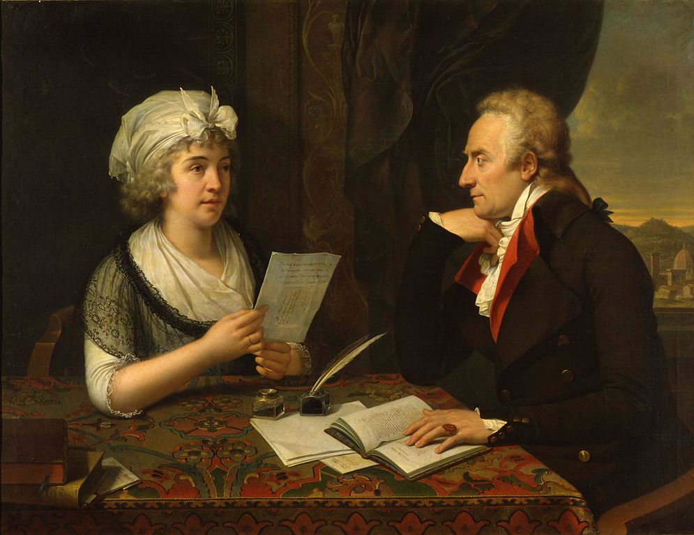 the image is an oil on canvas painting from the 18th century depicting johann wolfgang von goethe and christiane vulpius. a woman wearing a white headscarf and lace collar is standing on the left, holding a letter in her hands. on the right, a man with a wig and wearing a doublebreasted coat and red vest sits at a desk with an open book, inkwell, and quill. behind them, there's a cityscape or landscape visible through a window or opening. the painting depicts them in an intimate setting, showcasing their marital relationship.
