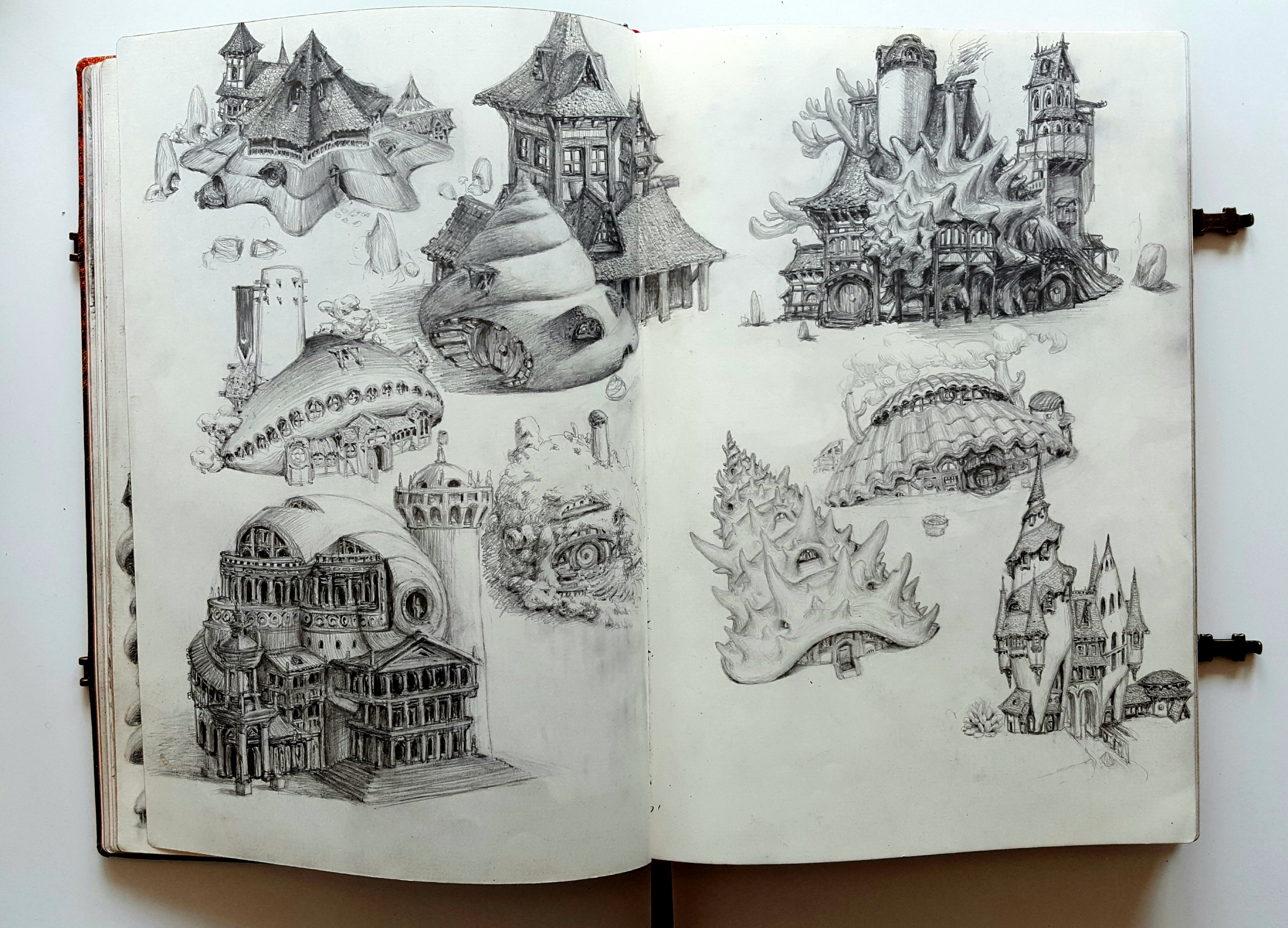 a sketchbook is open to two pages filled with graphite drawings of whimsical fantasy architecture. the drawings depict castles, houses, and other structures with imaginative and fantastical elements, showcasing a range of architectural styles and creative designs.