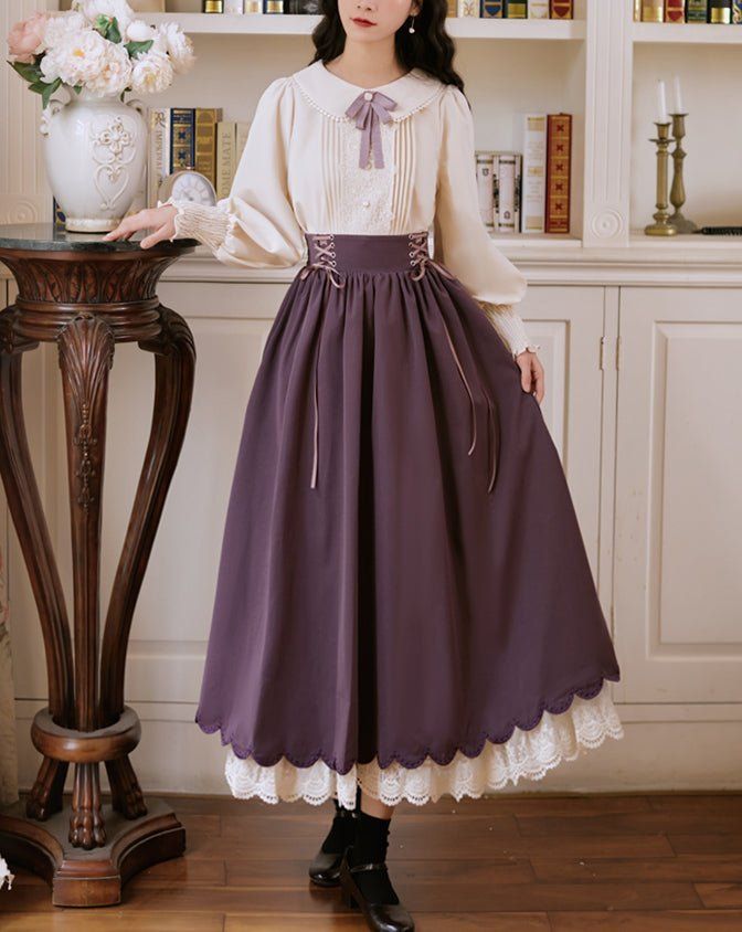 a woman stands in a room with built in bookshelves, wearing a long purple skirt with lace trim, and a creamcolored blouse with lace detailing. she has dark hair and is posing for the camera. the lighting is soft and natural, and the overall feel of the image is romantic and vintageinspired.