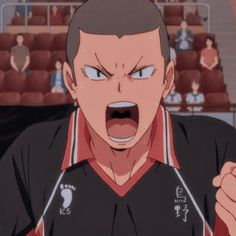 the image shows a closeup of an animestyle male character with a determined expression, likely a volleyball player midgame. he has short brown hair, and his mouth is wide open in a shout. he wears a black and red volleyball uniform with white accents, featuring japanese characters on the right side. the background suggests an indoor stadium setting with red bleachers and blurred figures of spectators. the lighting is bright and highlights the character's intense focus.