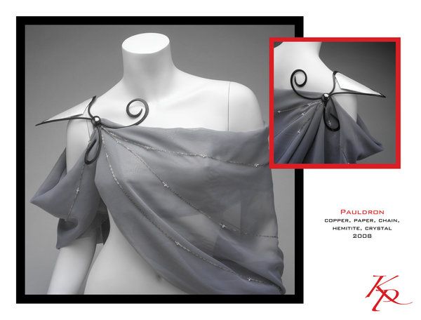 the image shows a piece of artistic jewelry described as a pauldron. it is made from copper, paper, chain, hematite, and crystal. the pauldron is draped on a white mannequin. the pauldron features a greytoned drape with subtle embellishments, appearing almost like a sheer fabric. it is held in place by a decorative metal element with a spiral design. a detail image on the upper right shows a closer view of the pauldron’s construction. the artwork is from 2008.