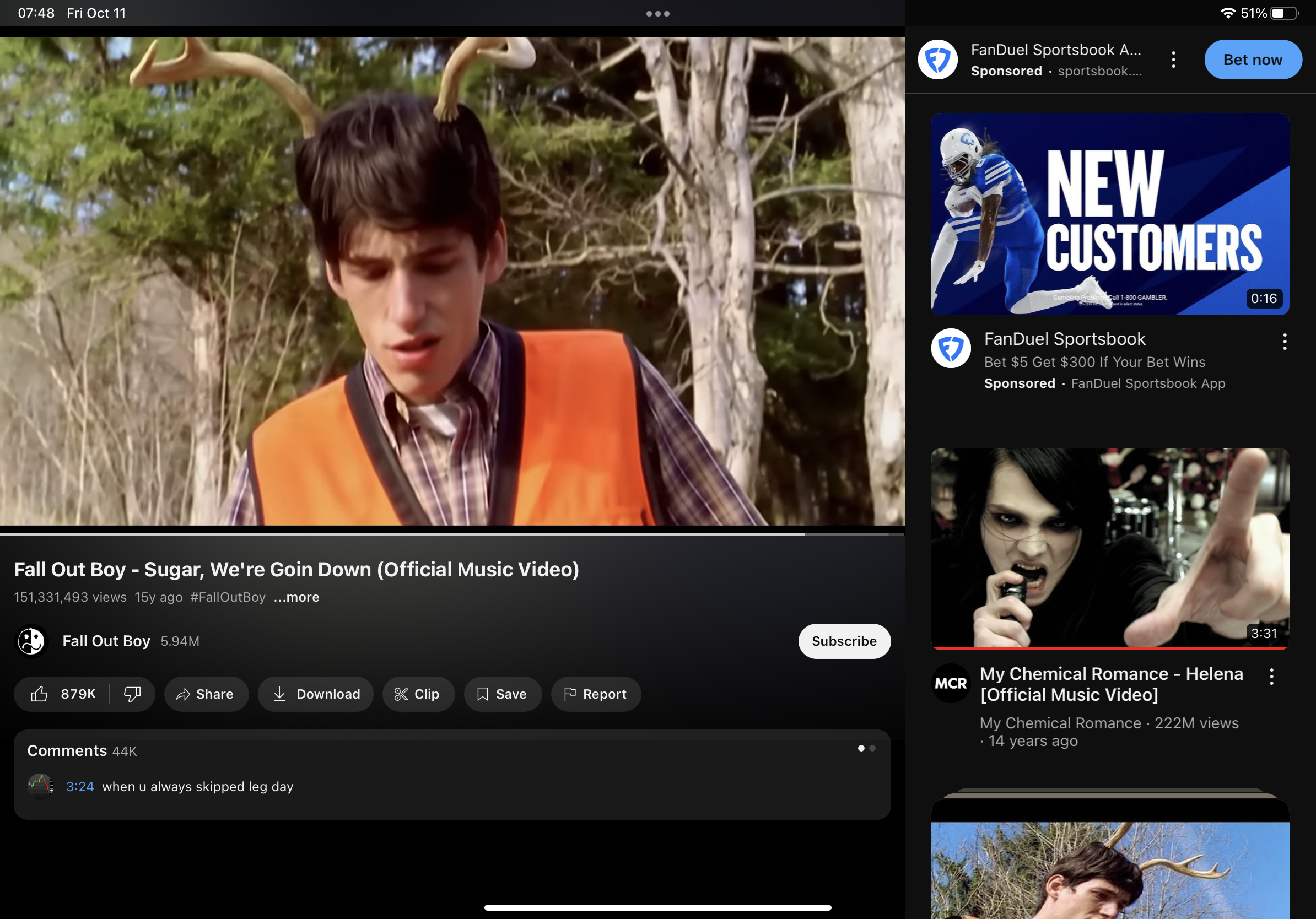 this is a screenshot of a youtube video playing the music video for "sugar, we're goin down" by fall out boy. the video is in portrait orientation, and the screen is divided into three parts: the top part shows the video itself, the middle part shows the video description and comments, and the bottom part shows related videos. the related videos include a music video by my chemical romance and an advertisement for fanduel sportsbook. the video is set in a forest and features a man with antlers on his head. the video is popular, with over 150 million views. the comments section is also active, with people discussing the video.
