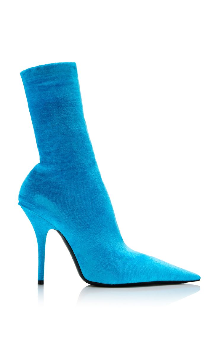 a pair of bright blue offwhite suede sock boots are shown on a white background. the boots are pointedtoe, highheeled stilettos with a socklike fit.  they are presented in a studio shot with a slight reflection visible underneath.